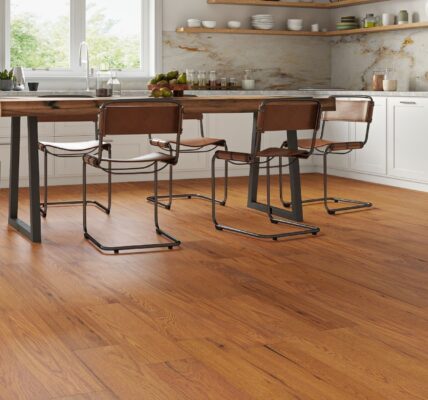 Golden-brushed UV oiled oak engineered wood flooring installed in a bright modern kitchen with a rustic dining table and white cabinets.