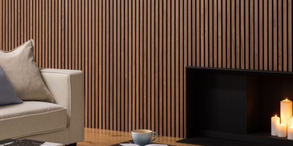 Deep walnut acoustic slatwall panelling mounted on a living room wall behind a sofa and fireplace
