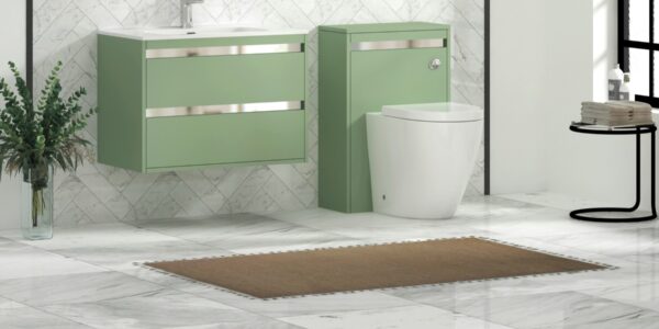 Modern bathroom featuring a wall-hung mint/sage green vanity unit with a white ceramic basin and chrome trim, paired with a matching back-to-wall toilet unit. The space is finished with white marble tiled walls in a herringbone pattern, light marble floor tiles, a brown bath mat, and decorative greenery in a clear vase.