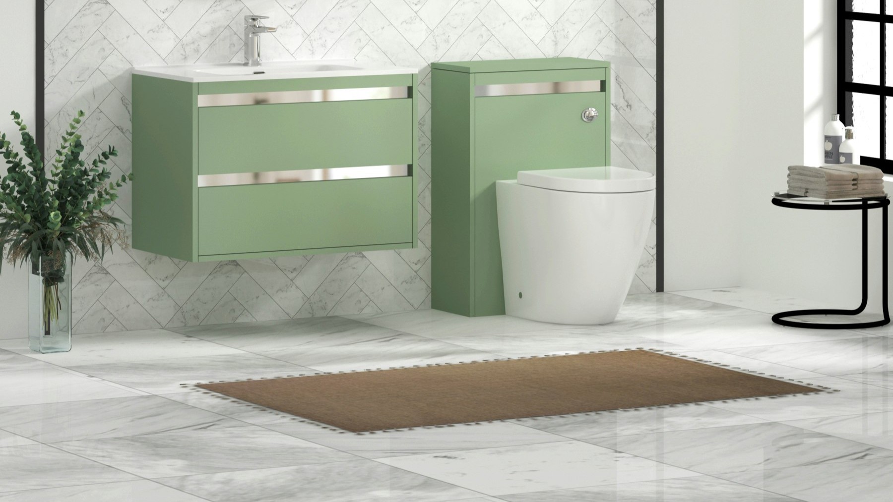 Modern bathroom featuring a wall-hung mint/sage green vanity unit with a white ceramic basin and chrome trim, paired with a matching back-to-wall toilet unit. The space is finished with white marble tiled walls in a herringbone pattern, light marble floor tiles, a brown bath mat, and decorative greenery in a clear vase.