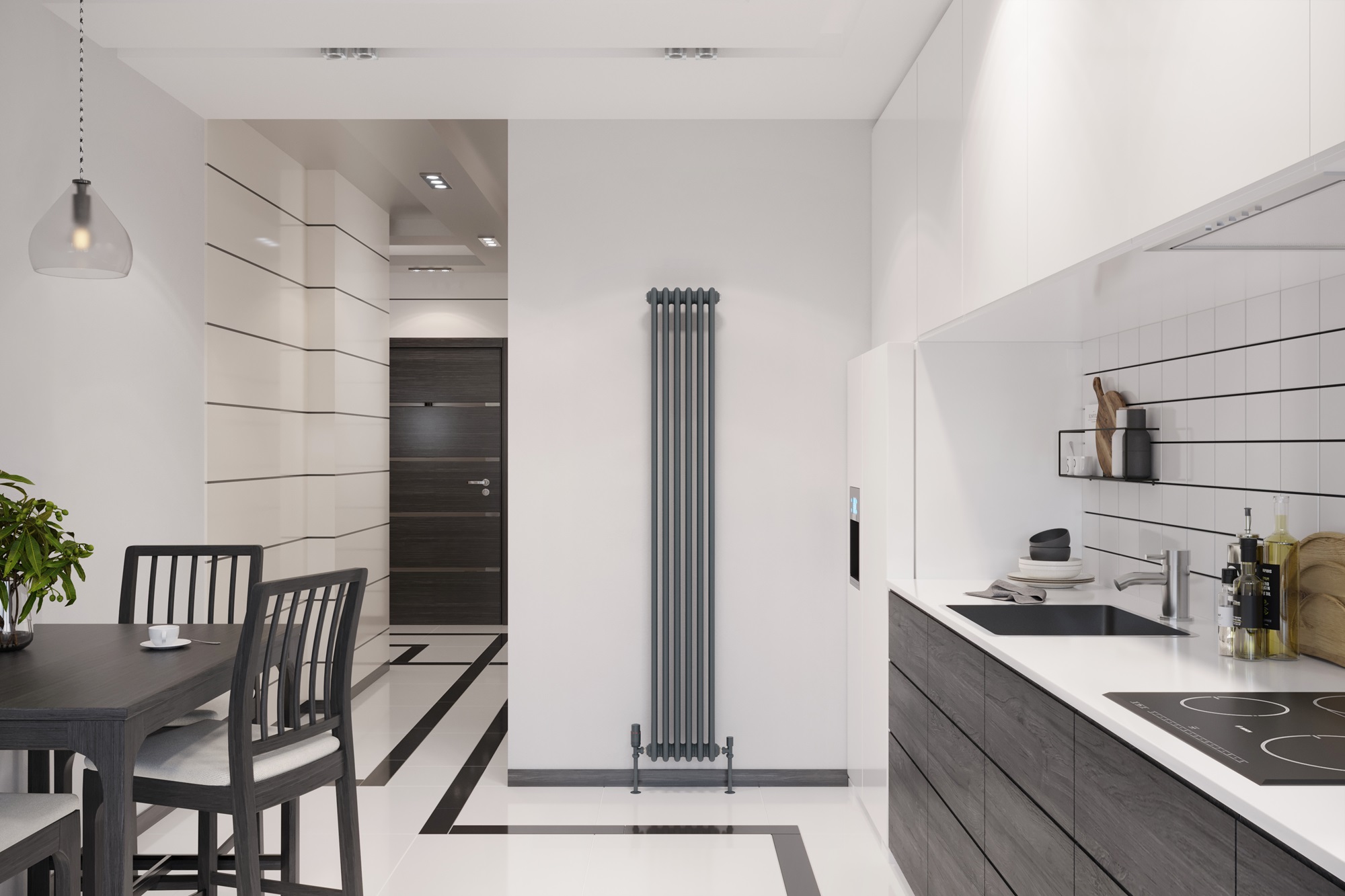 a modern kitchen and dining area with a minimalist design. The space is dominated by a monochromatic color scheme, featuring shades of white, black, and gray. A sleek, dark dining table with four matching chairs is placed on the left side of the image, under a simple hanging pendant light. To the right, the kitchen area is equipped with white cabinetry and black countertops. The backsplash consists of white rectangular tiles with dark grouting, and there are various kitchen items like pots, a cutting board, and bottles of oil on the counter. In the center of the image is a tall, vertical, anthracite-colored column radiator, and there's a modern dark door in the background on the left. The flooring is a geometric pattern of white and black tiles that complement the overall contemporary aesthetic of the room.