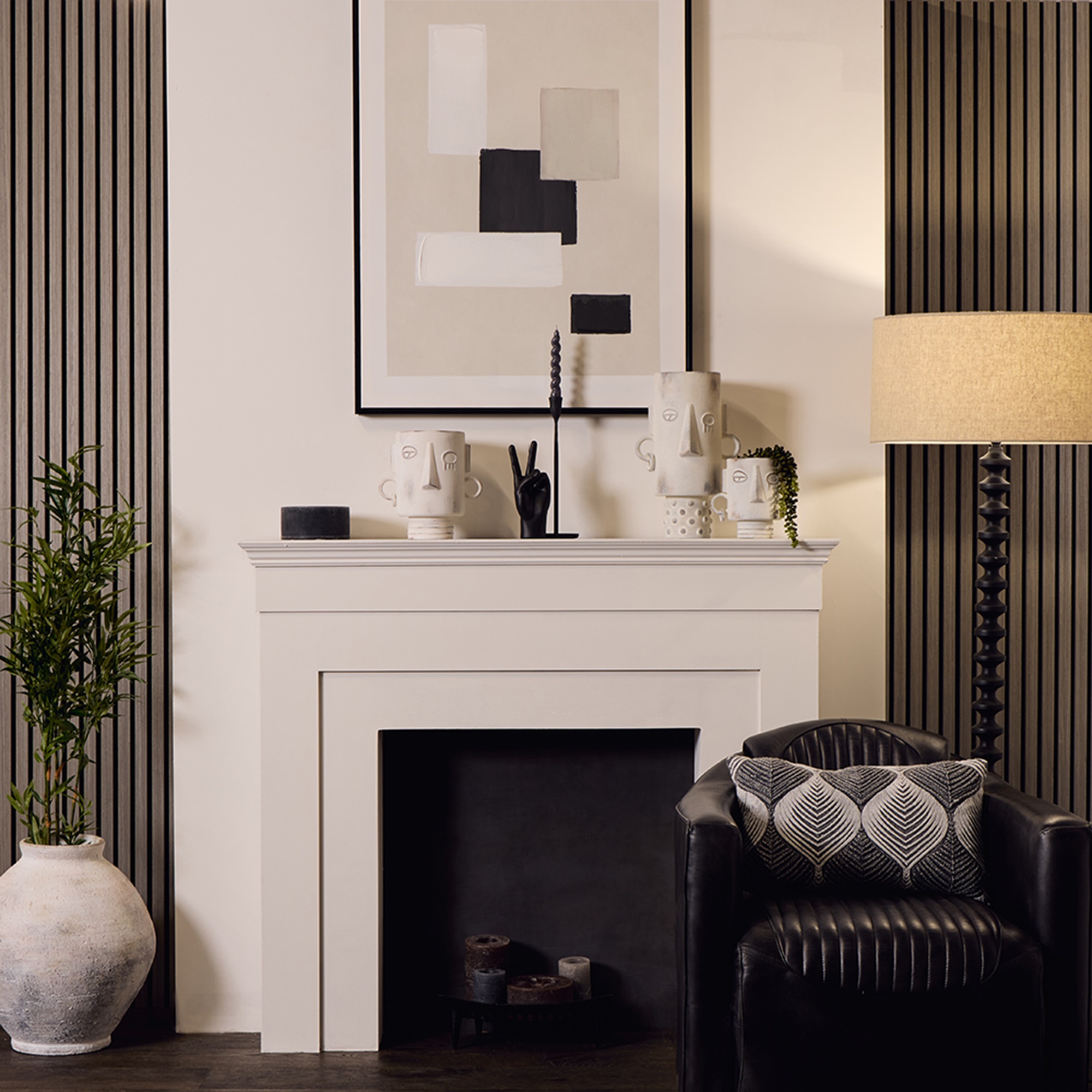 A decorative vase with a blue stone effect and black details. The design is simple and modern, with a series of black droplet-like patterns arranged in rows around the body of the vase. The neck of the vase is narrow and cylindrical, contrasting with the wider base, giving it an elegant profile that could complement a contemporary interior design.