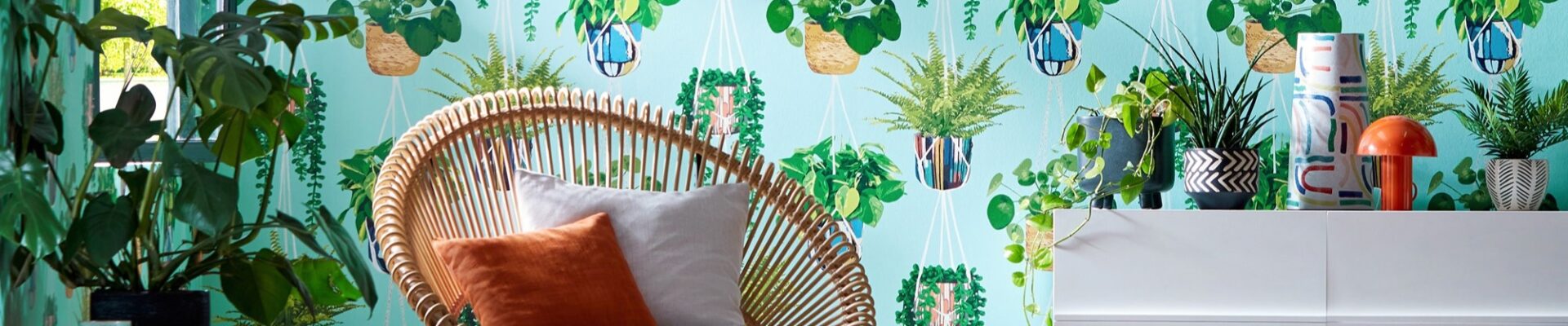 A modern room with a chair in front of a patterned wallpaper featuring white hanging planters.