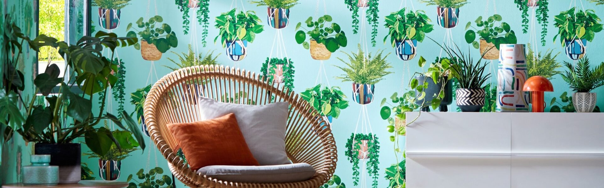 A modern room with a chair in front of a patterned wallpaper featuring white hanging planters.