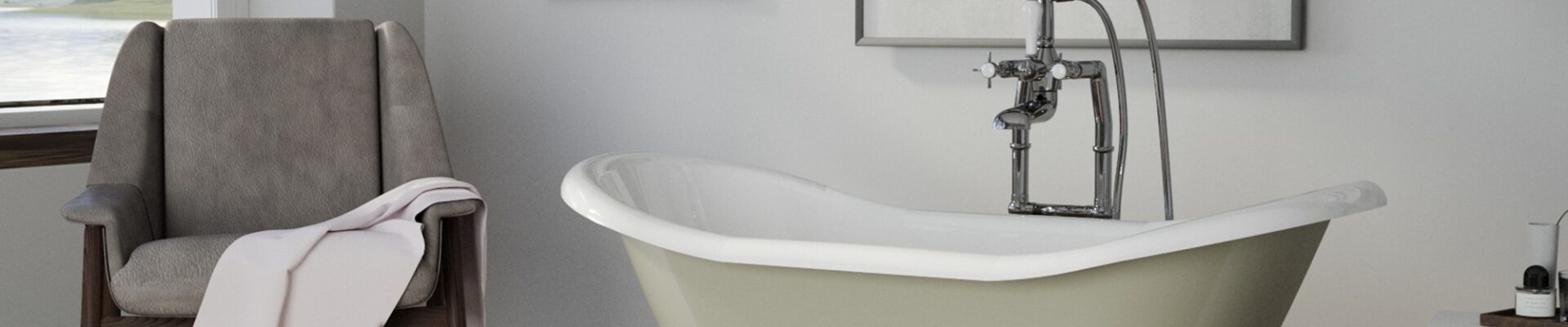 A white clawfoot bathtub with rolled edges sits in a bathroom with patterned tile floors. A wooden chair with a towel draped over it sits beside the bathtub.