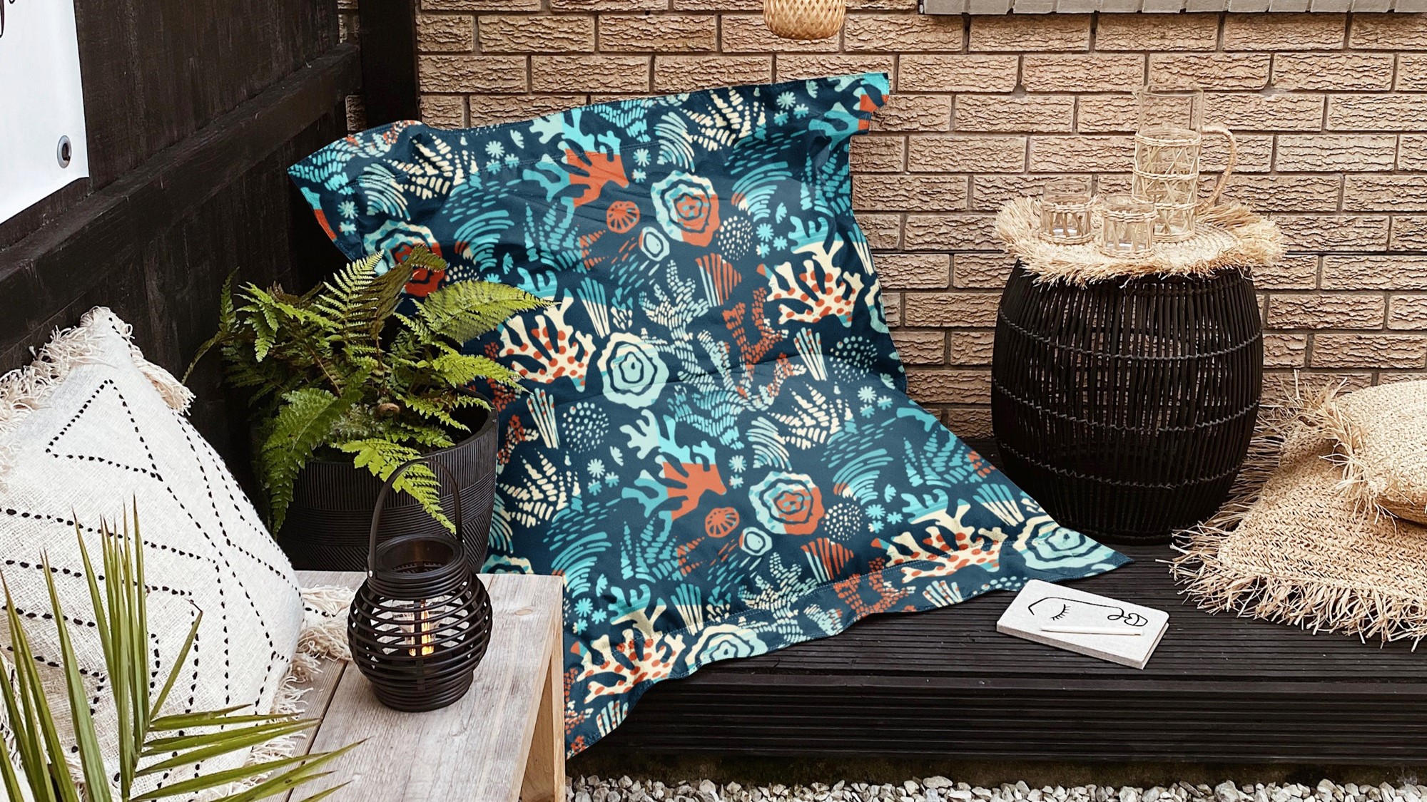 A photo of a patio with a bean bag chair and pillows on the ground.
