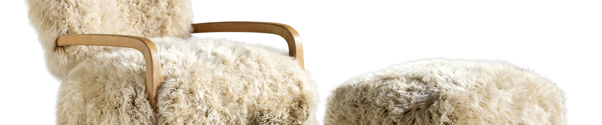 A luxurious white fur chair and footrest set against a crisp white backdrop.