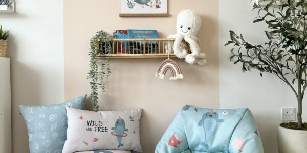 A cosy room with a beanbag chair, ottoman, and pillows.