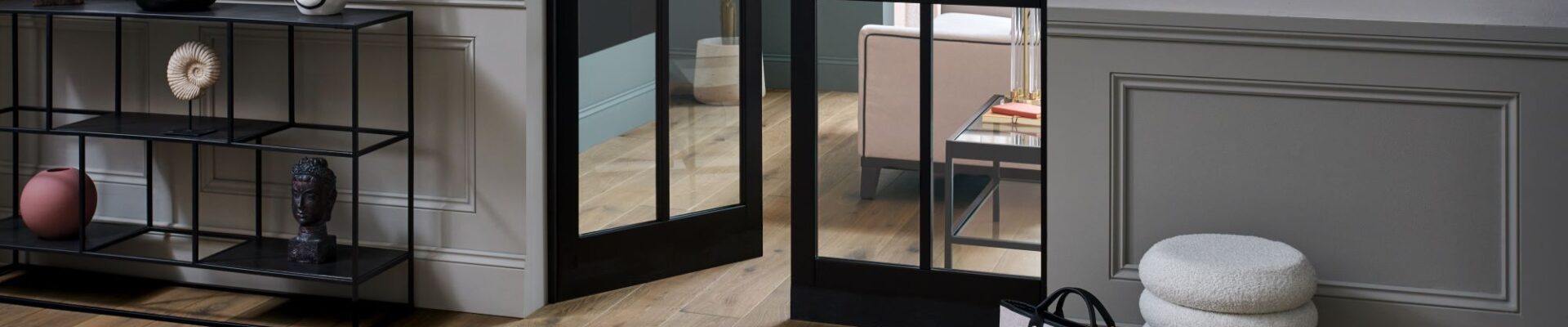 Living space with wooden floor and closed door at the end
