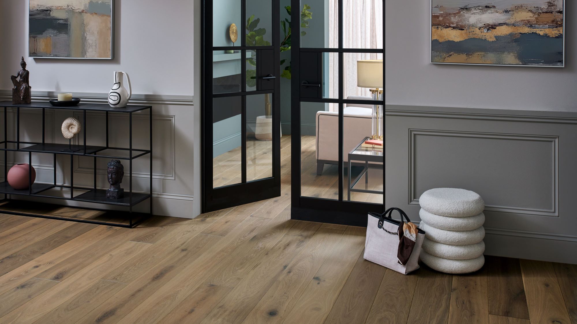 Living space with wooden floor and closed door at the end