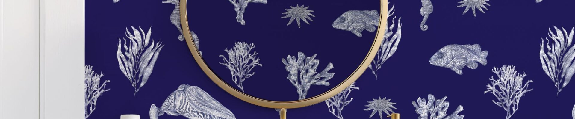 Bathroom with blue patterned wallpaper and a gold framed mirror