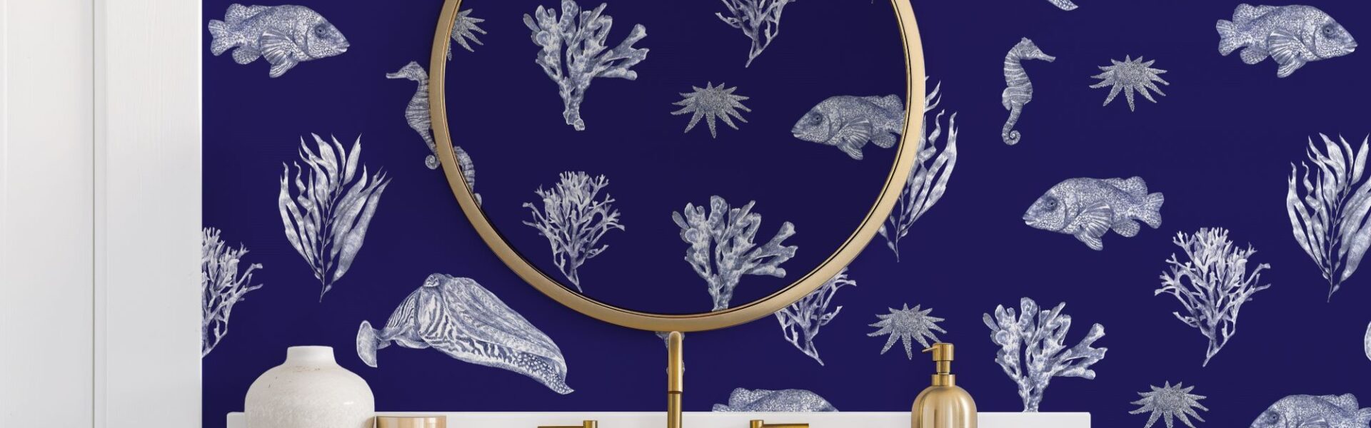 Bathroom with blue patterned wallpaper and a gold framed mirror