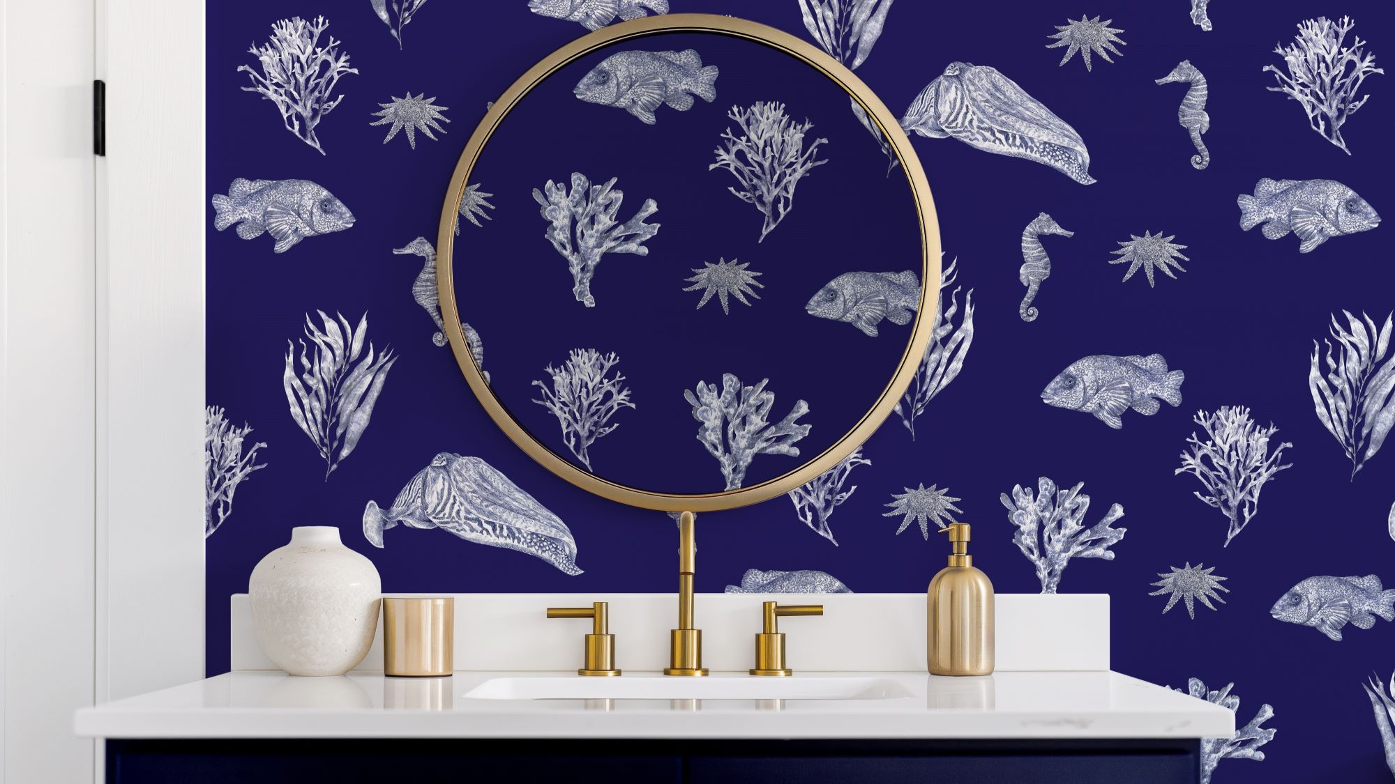 Bathroom with blue patterned wallpaper and a gold framed mirror