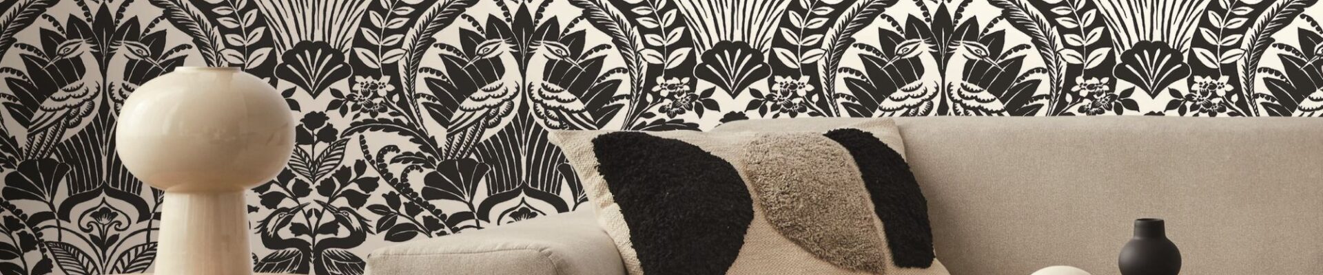 A detailed portion of wallpaper, highlighting an intricate pattern of large, exotic leaves in various shades.