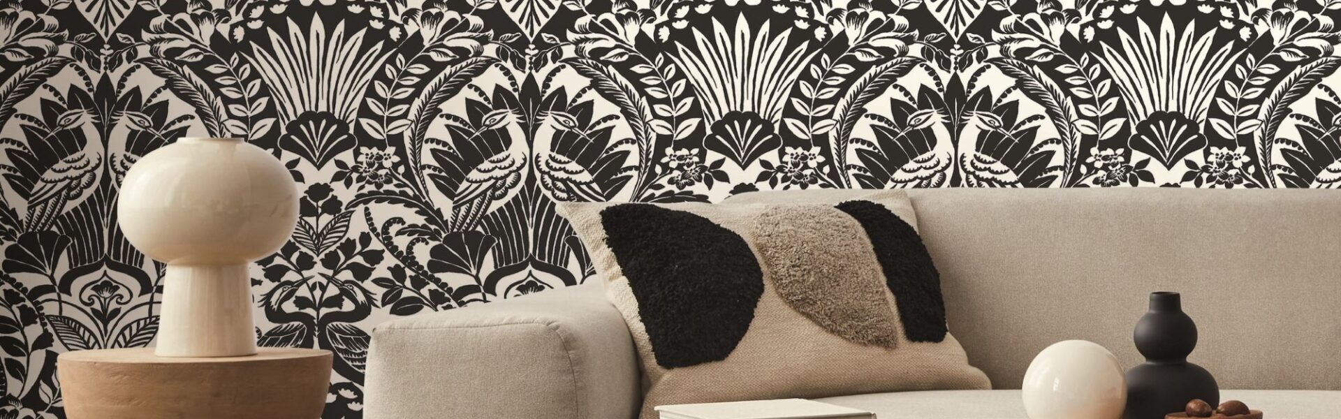 A detailed portion of wallpaper, highlighting an intricate pattern of large, exotic leaves in various shades.