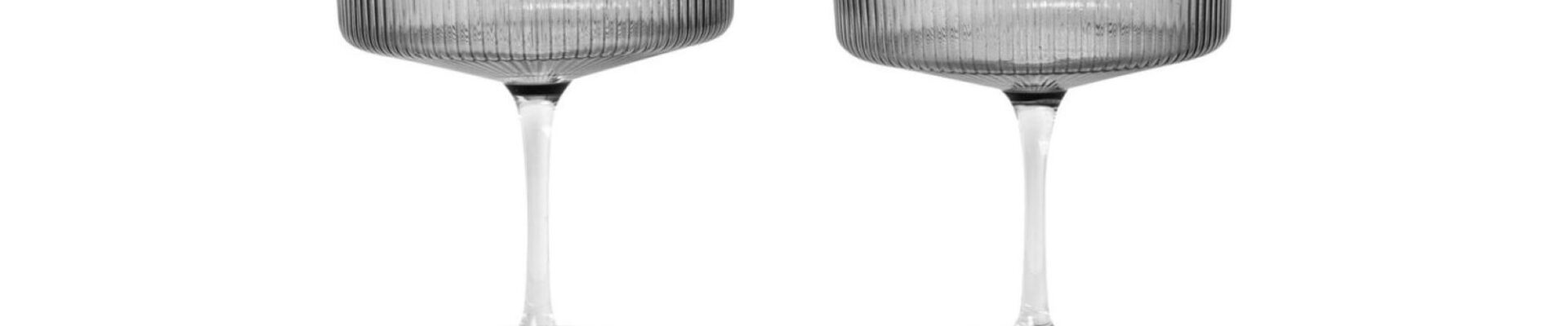 Two smoked grey champagne glasses on a white background.