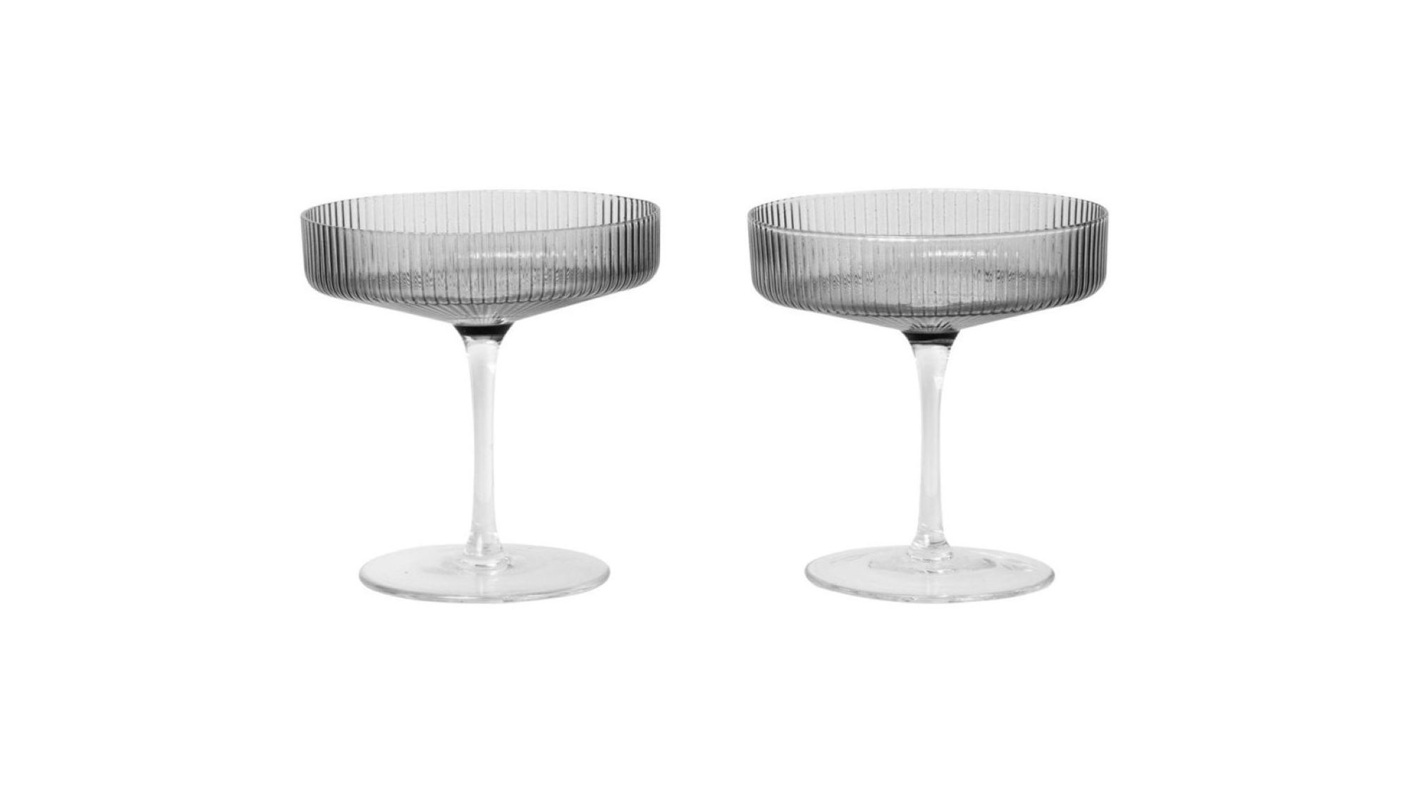 Two smoked grey champagne glasses on a white background.