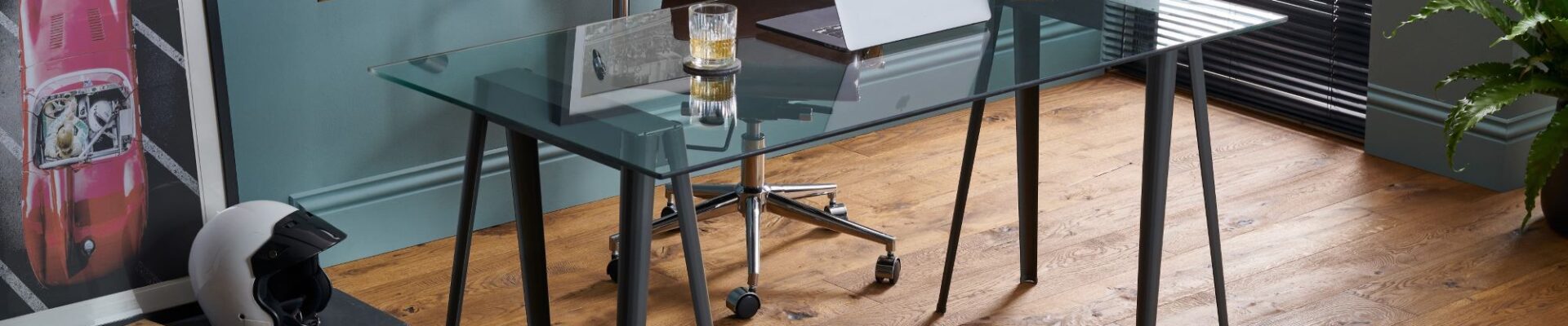 The image shows a modern home office space with dark wood floors and a glass desk.