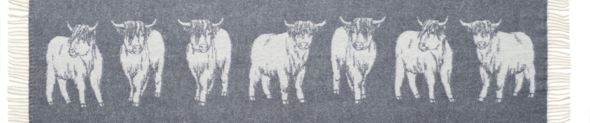 The image shows a Highland Cow Bed Runner. The distinctive shaggy coat and long horns of the cows are seen clearly. It's a charming and cosy addition to any home.