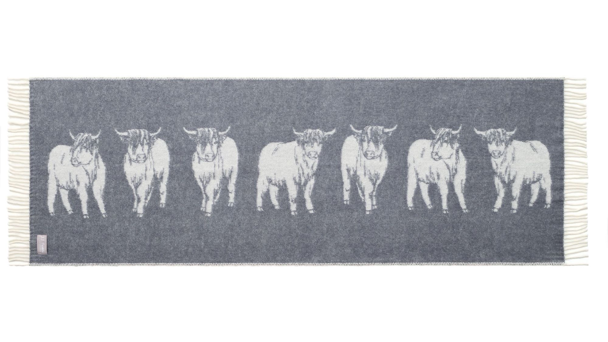The image shows a Highland Cow Bed Runner. The distinctive shaggy coat and long horns of the cows are seen clearly. It's a charming and cosy addition to any home.