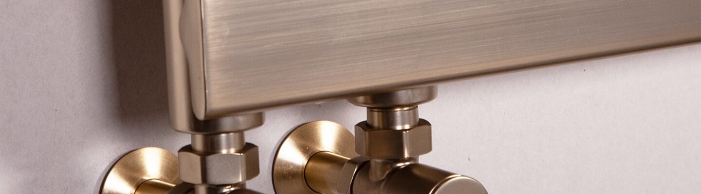 Luxurious brushed brass heated towel rail with stylish round valves