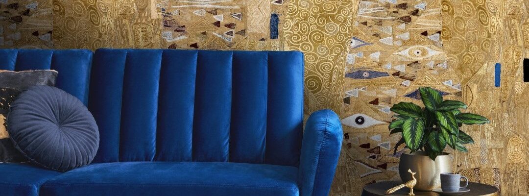 The wallpaper features a large-scale abstract design with golds, browns, and blues. There are hints of faces and eyes within the pattern, giving it a surreal and intriguing quality.
