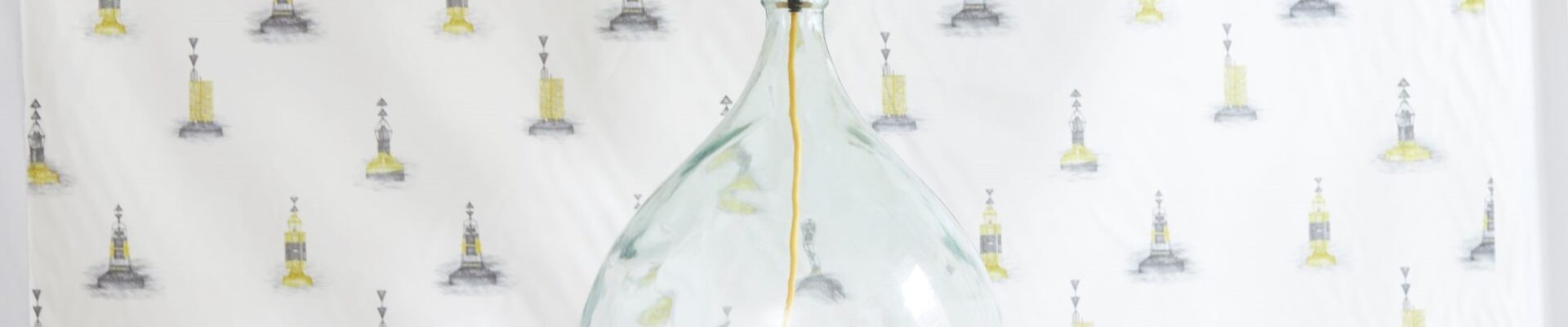 Made from a large, clear glass bottle. The bottle has a rounded, bulbous shape, giving it a distinctive look. The base is likely repurposed from a wine or liquor bottle.