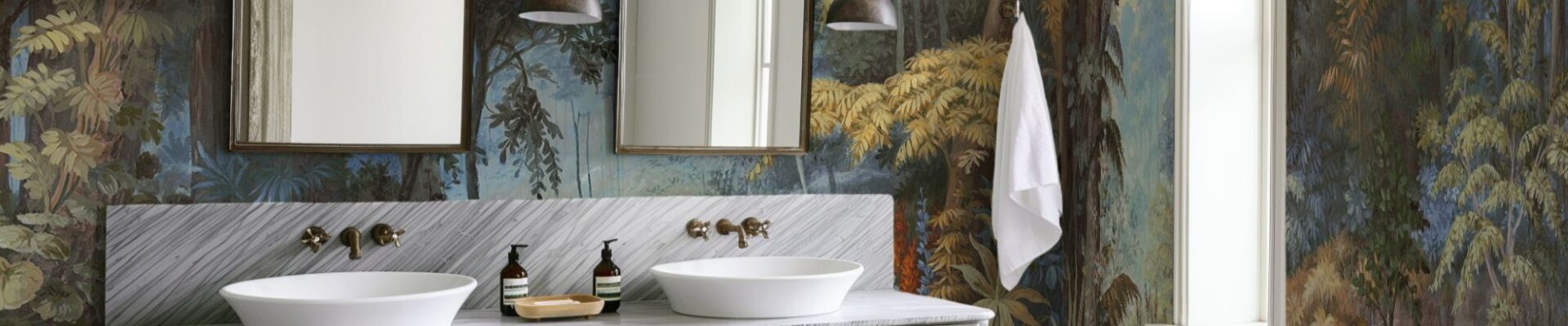 The wallpaper features a nature-inspired mural with trees and foliage in various shades of blue, green, brown, and yellow. This creates a strong visual impact and adds depth to the room.