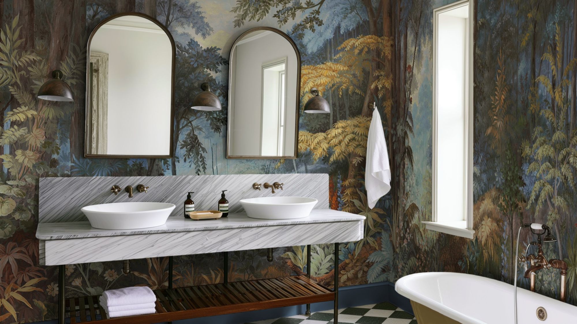 The wallpaper features a nature-inspired mural with trees and foliage in various shades of blue, green, brown, and yellow. This creates a strong visual impact and adds depth to the room.