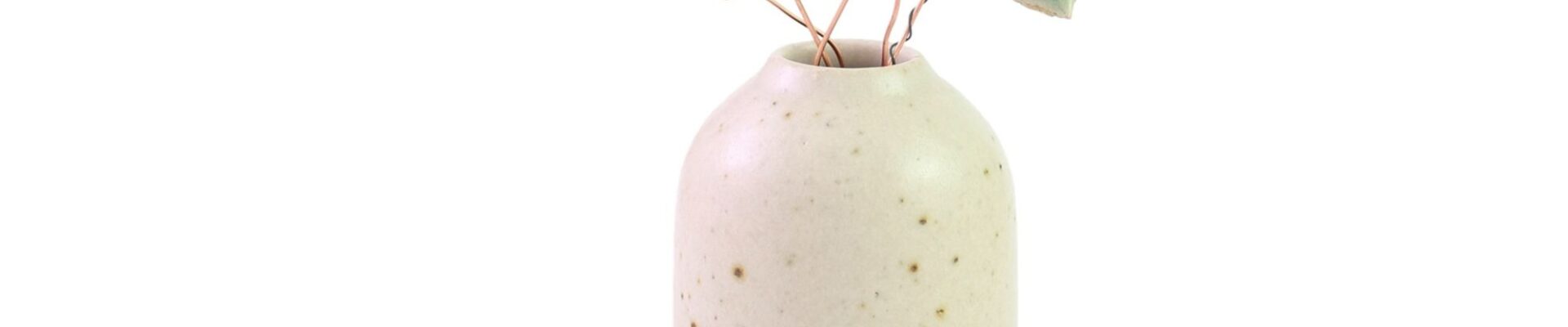 A small, cream-colored ceramic vase with speckled detailing, holding several delicate, pastel-coloured ceramic wildflower stems. The flowers are in shades of blue, pink, and yellow, and are attached to thin, brown wire stems. One stem also features a small, green ceramic leaf.