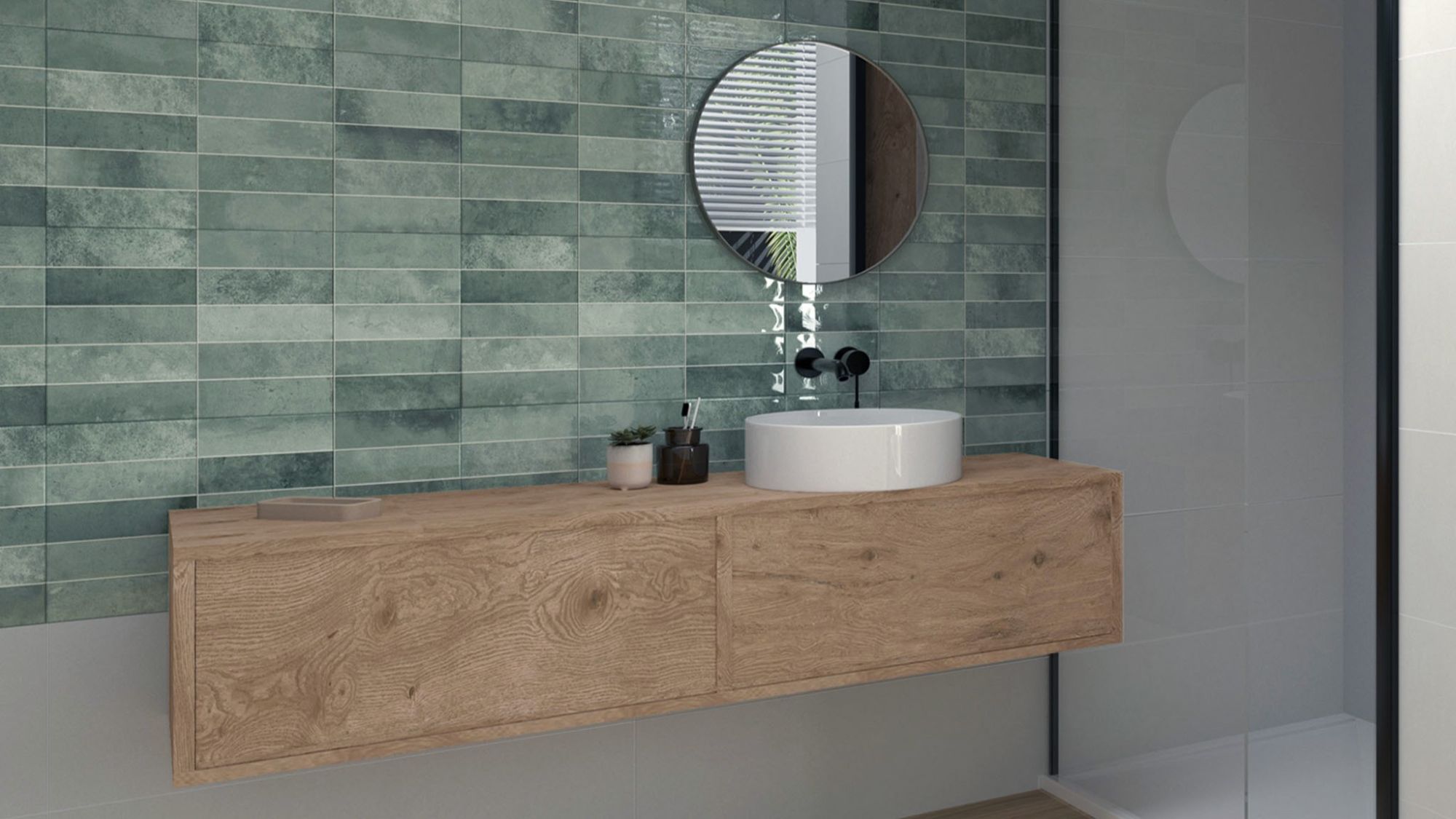 A modern bathroom interior with a focus on a stylish wall tiles. The dominant feature is the wall covered in rectangular tiles with a muted green hue. The tiles have a slightly distressed or textured appearance, adding depth and character.