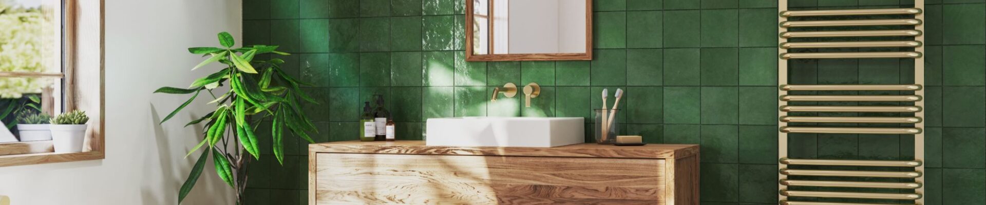 A modern bathroom with green tiles, a brass towel rail and wooden vanity.