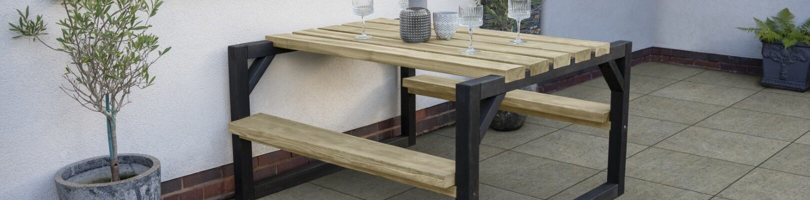 A wooden picnic table and attached benches on a patio, perfect for summer dining.