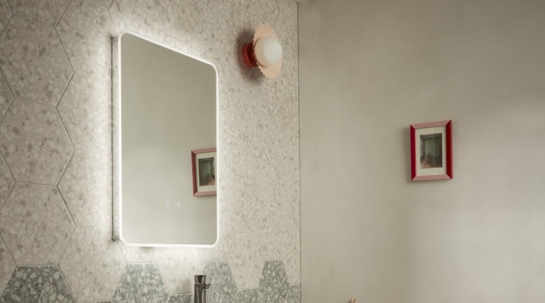 A rectangular mirror with a light glow around the border brings an ethereal feel to bathrooms