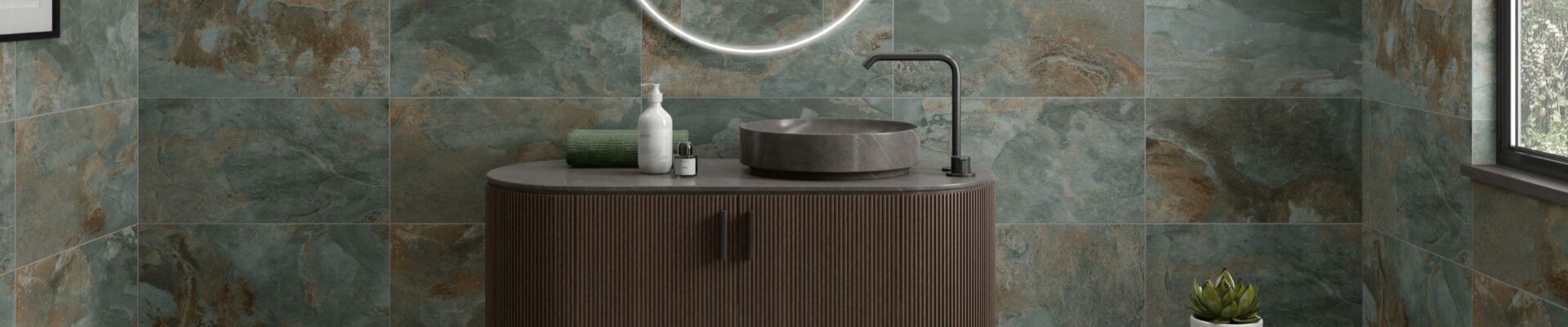 A modern bathroom featuring walls tiled with Strata Green tiles. The tiles have a distressed, multi-tonal appearance with shades of green, brown, and grey.