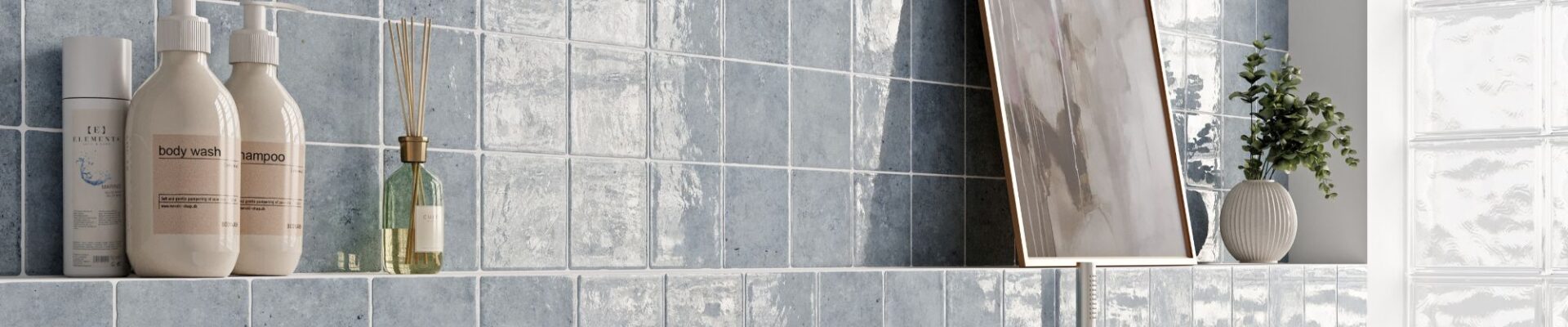 A bathroom scene featuring light blue, square wall tiles with a glossy, uneven surface. The tiles are arranged in a grid pattern with white grout lines.