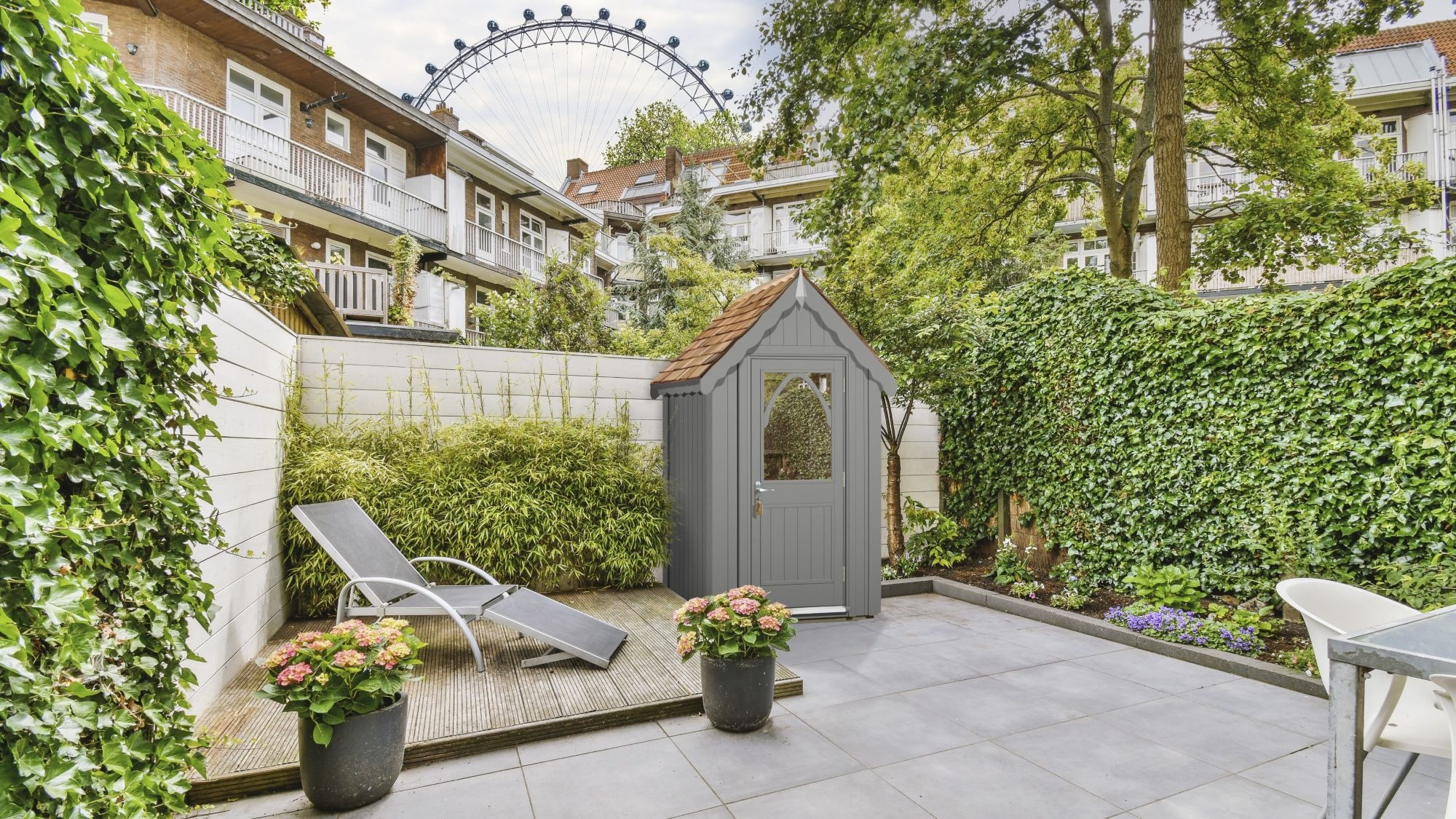 A stylish garden shed, named The Ludlow Shed by The Posh Shed Company, priced at £3999. The shed is grey with a red roof and features a window and a door, situated in a contemporary patio garden.