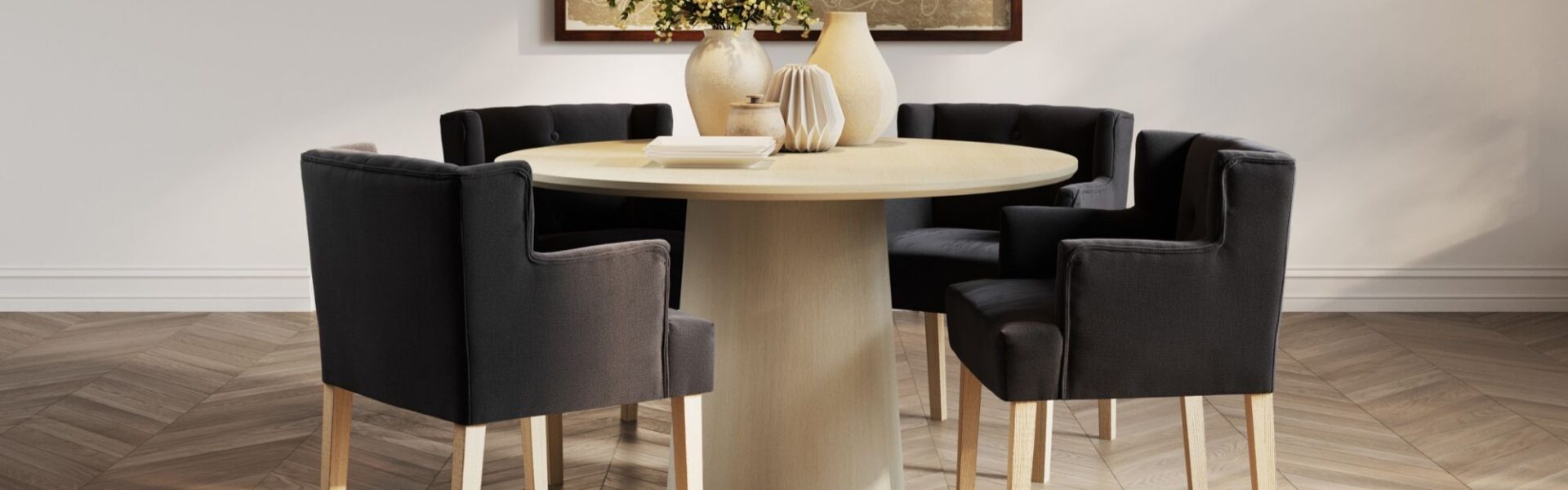 This lifestyle image showcases four Ari-Winged Dining Armchairs in anthracite, a dark gray colour, surrounding a light wood dining table. The chairs feature a clean, contemporary design with a winged backrest that curves slightly around the sides. They are upholstered in a linen blend fabric and rest on light wood legs, which complement the table.