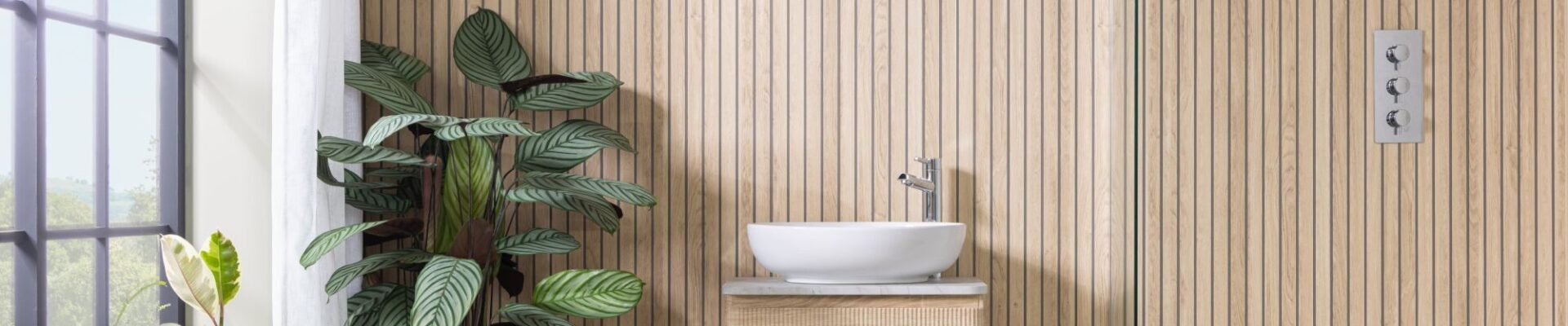 Image shows a bathroom with light wood wall panels laid vertically in a slatted effect.