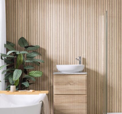 Image shows a bathroom with light wood wall panels laid vertically in a slatted effect.