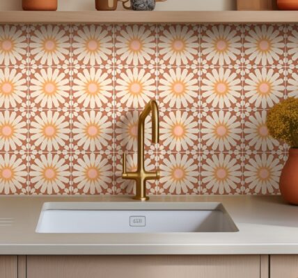 The backsplash is covered in ceramic tiles with a repeating floral pattern. The tiles are a warm terracotta colour with a large, stylized daisy design in the centre of each one. The daisy petals are a light cream or off-white, and the centres are a soft pink.