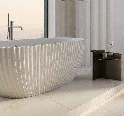 A luxurious and modern bathroom setting, dominated by a large, freestanding bathtub.