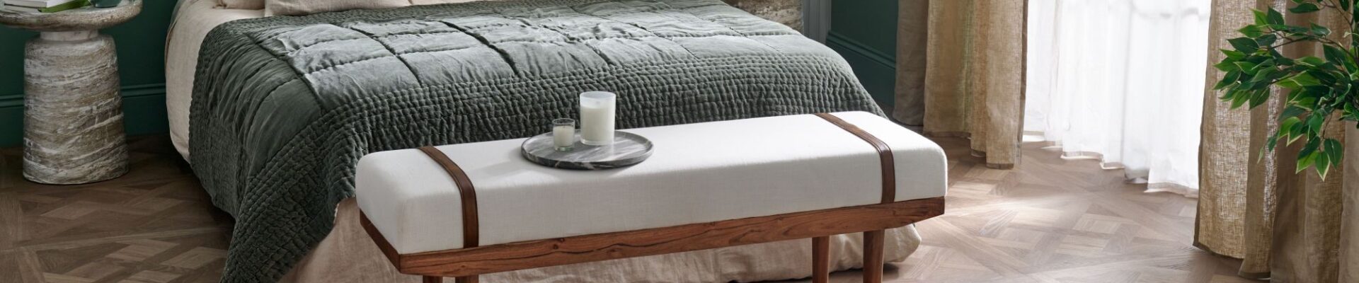 A beautiful calming bedroom featuring statement wood-effect design panels and a large double bed. In the background is a green wall and sheer curtains finish the look.