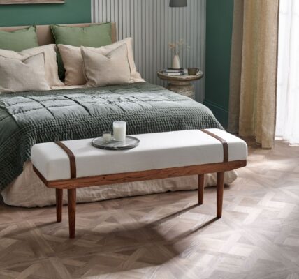 A beautiful calming bedroom featuring statement wood-effect design panels and a large double bed. In the background is a green wall and sheer curtains finish the look.