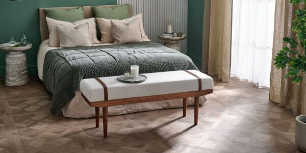 A beautiful calming bedroom featuring statement wood-effect design panels and a large double bed. In the background is a green wall and sheer curtains finish the look.