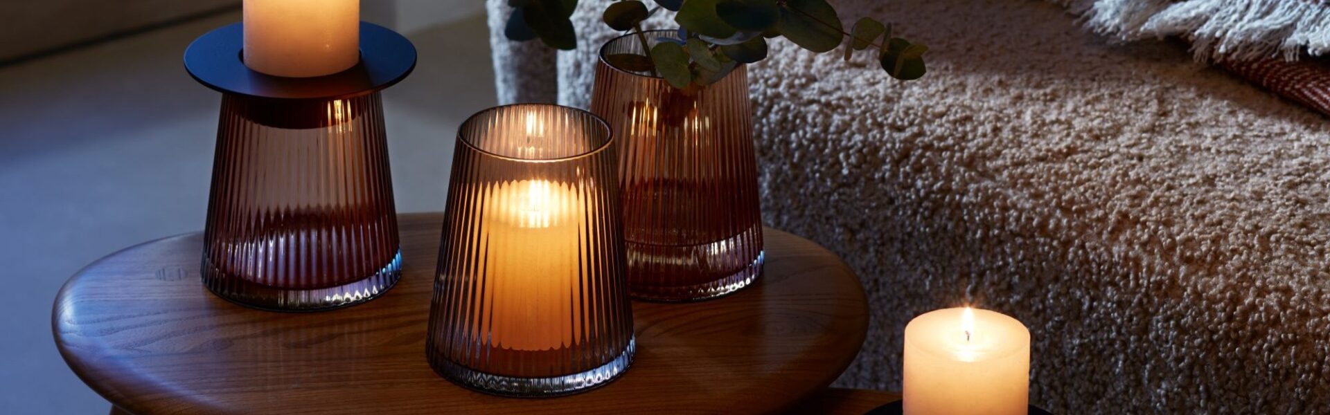 A beautiful arrangement of LSA International glassware and candles, creating a warm and cozy atmosphere.