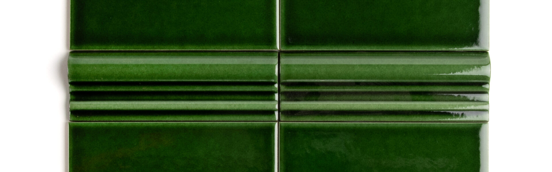 A rich, dark, emerald green tile with a high-gloss finish and dado detailing