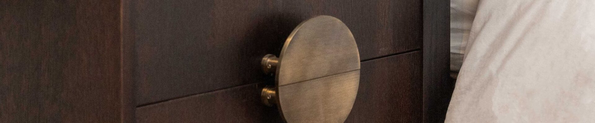 A Solid Brass Half Moon Handle in an Antique Gold or Brushed Brass finish. These handles are typically sold as a pair, allowing them to be mounted back-to-back to form a full circle, as seen in your image on the two drawers of the dark wooden cabinet.