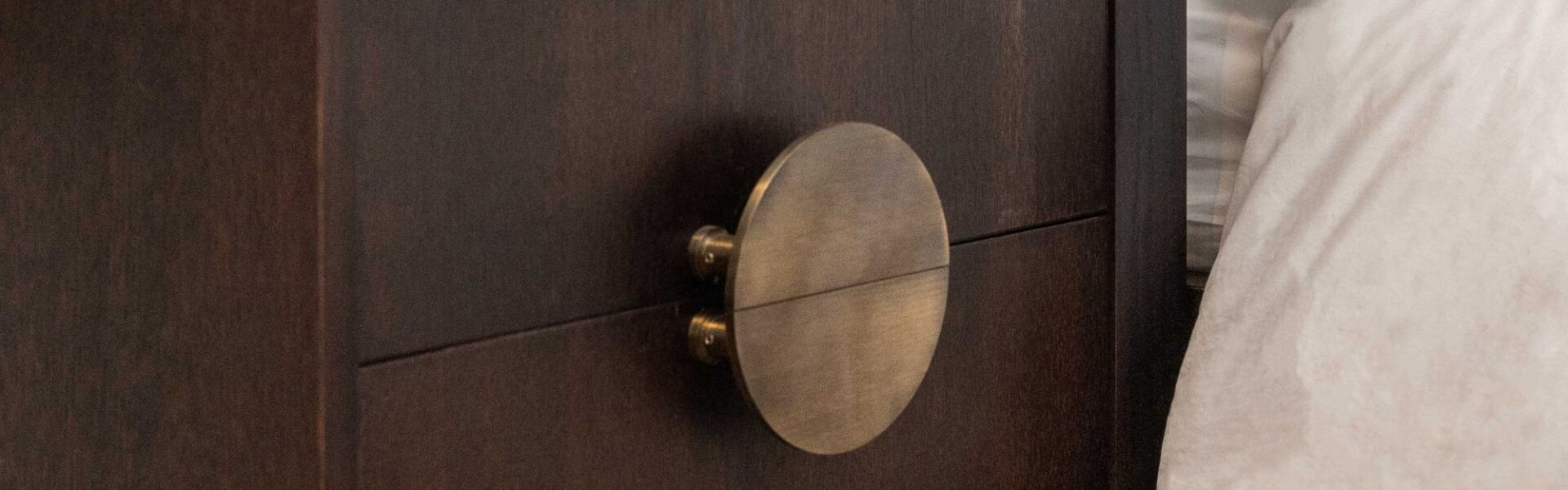 A Solid Brass Half Moon Handle in an Antique Gold or Brushed Brass finish. These handles are typically sold as a pair, allowing them to be mounted back-to-back to form a full circle, as seen in your image on the two drawers of the dark wooden cabinet.