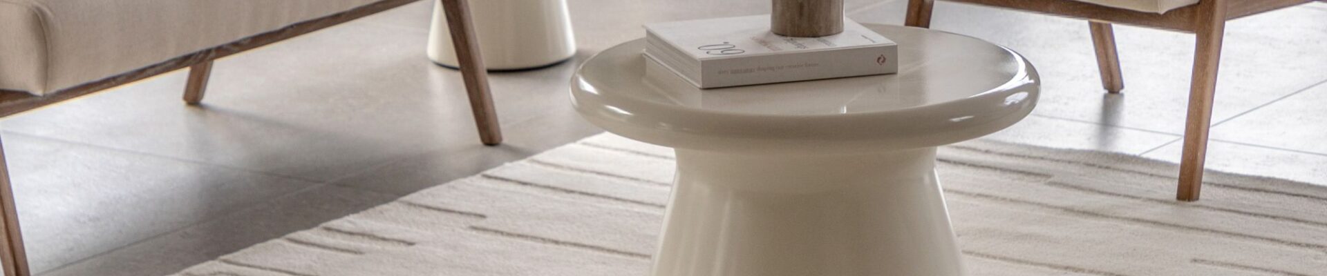 A modern, neutral-toned living area, focusing on a rectangular Tufted Tonal Rug in white or a very light cream colour.